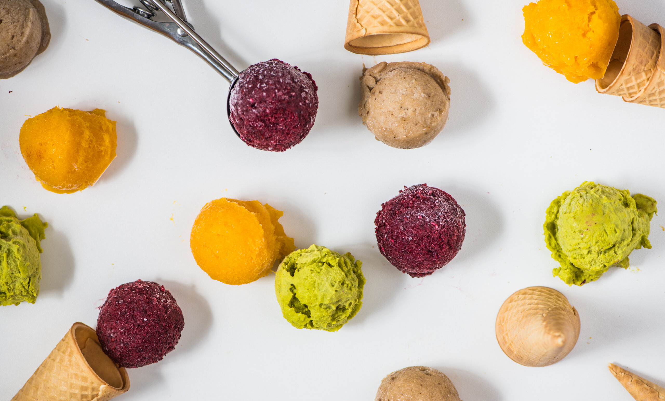vegan ice cream on the table with cone, banana, raspberry, avocado and mango